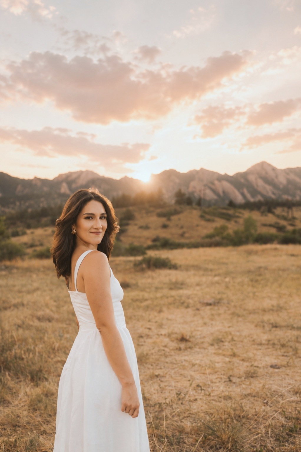 A woman looking out over the mountains at golden hour.